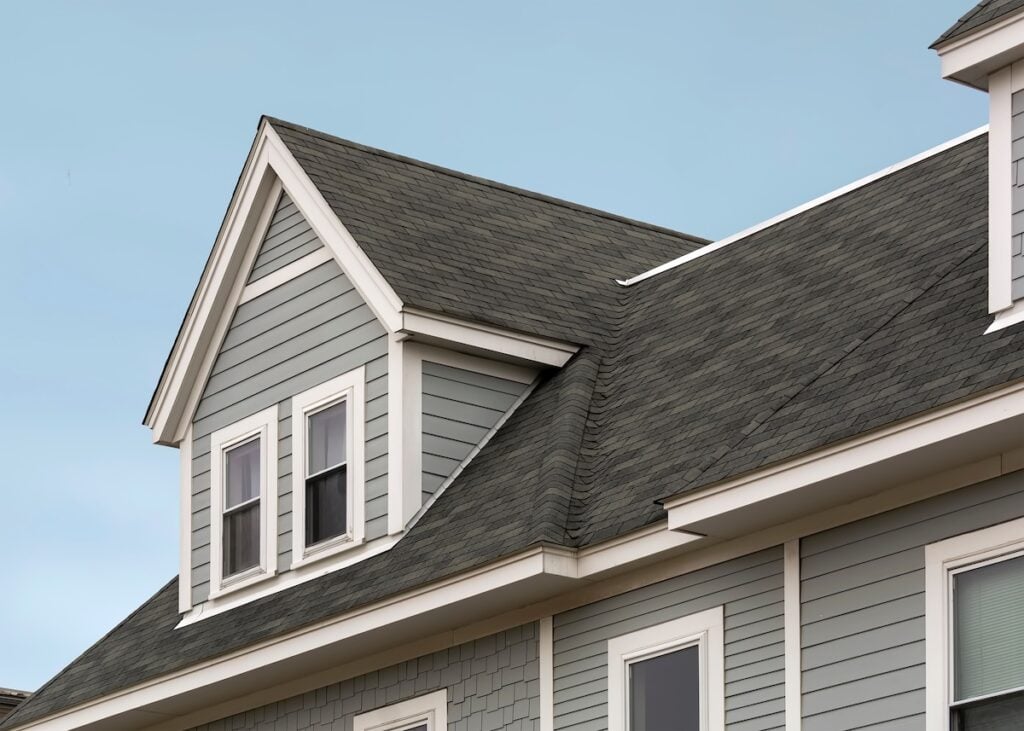 how to get insurance to pay for roof replacement Detailed view of a gable-style dormer window on a sloped roof of a newly built family house