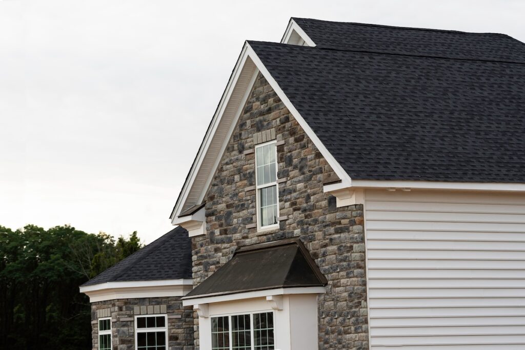 edge of roof shingles on top of the house dark asphalt tiles on the roof background color