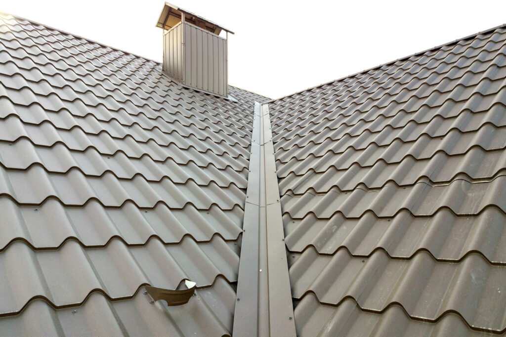 Close up of new house roof structure covered with metal tile sheets.