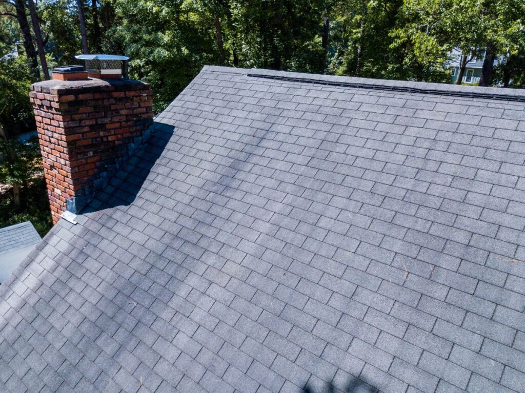 architectural shingles vs 3 tab charcoal roof summer time brick wall chimney