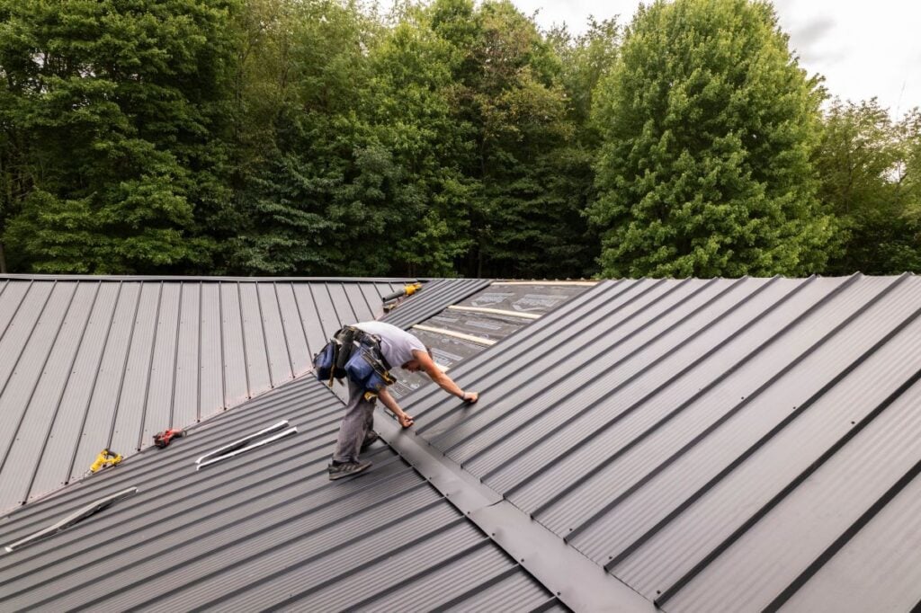 metal roof cost Keim Quality Roofing worker installing new roof