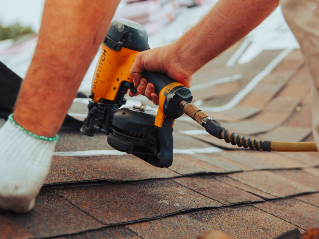 does home insurance cover roof repair Keim Quality Roofing workers close up nail gun