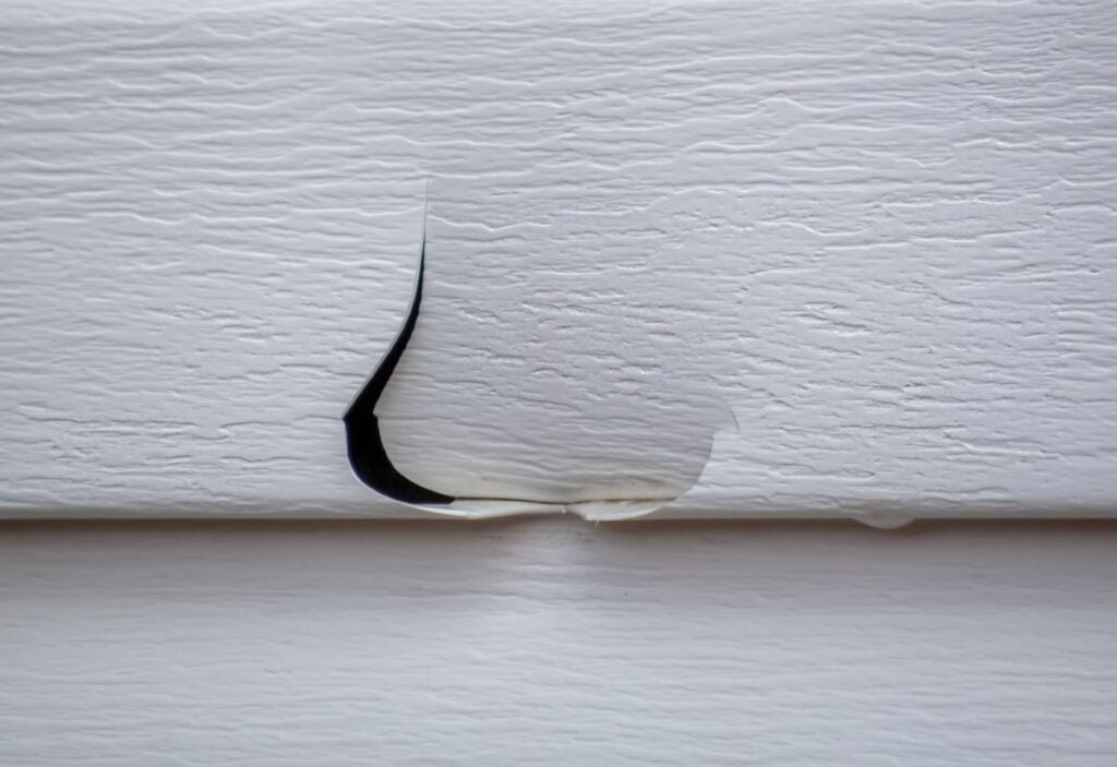 what does hail damage look like on siding closeup white siding cracked